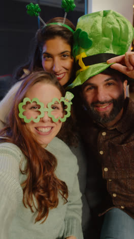 Vertical-Video-Of-Friends-Dressing-Up-At-Home-Or-In-Bar-Celebrating-At-St-Patrick's-Day-Party-Posing-For-Selfie-On-Phone-In-Real-Time-2
